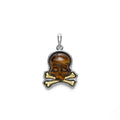 Intricately crafted tiger eye gemstone, 18K gold, and sterling silver form this skull and bones motif amulet.
