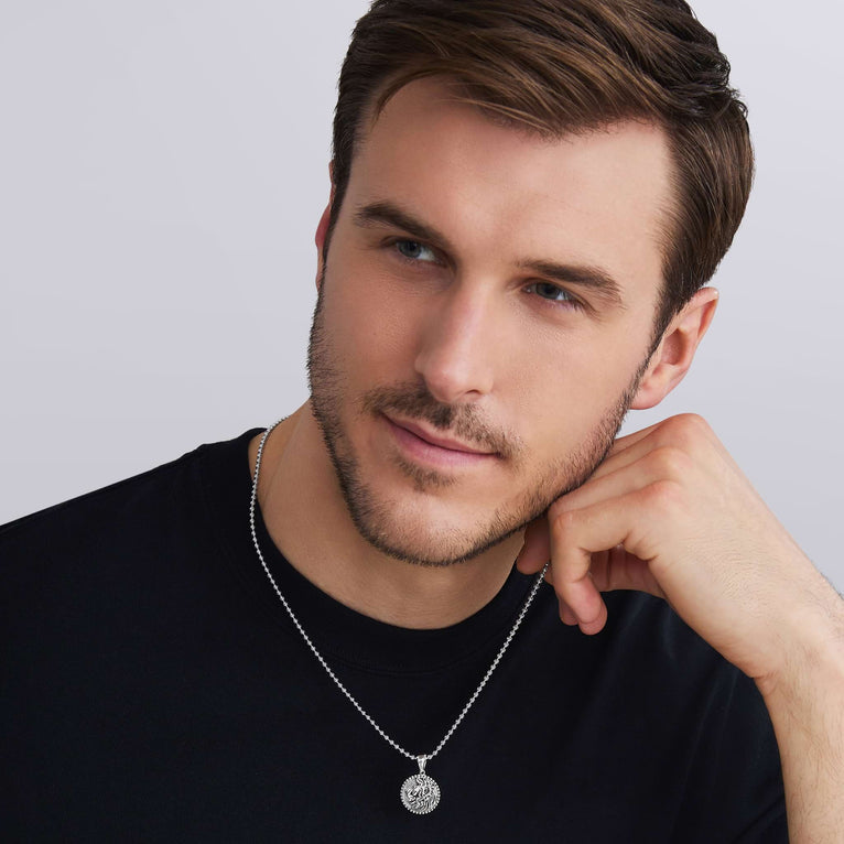 man wearing Small Silver Lion Circle Amulet displayed on a necklace, demonstrating its universal Jr bale compatibility