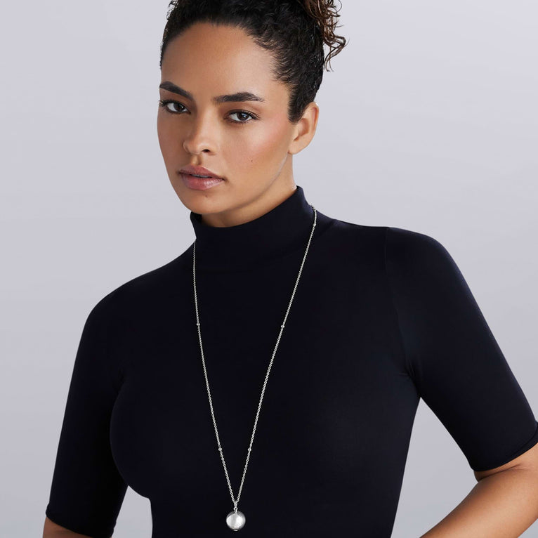 Woman wearing long necklace with sterling silver bead pendant