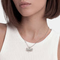 Woman wearing a Rare Wonders Sterling Silver Mini Dragonfly Pendant Necklace with detailed wings on a delicate chain, paired with a ribbed top.