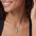 Rare Wonders Sterling Silver Mini Seahorse Pendant Necklace displayed on a smiling person, featuring a detailed seahorse charm on a delicate chain, framed by dark wavy hair.