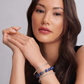 Woman showcasing the Signature Caviar Lapis Gemstone and Bangle Bracelet Gift Set with polished lapis beads and sterling silver bangles on wrists.