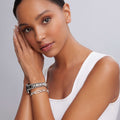 Young woman with medium-brown skin wears LAGOS Smart Caviar Silver Link Gift Set, featuring a chunky watch and chain bracelet on her wrist.