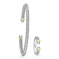 Silver and gold bracelet with matching ring on a white background