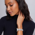 Woman wearing a Smart Caviar Sterling Silver Watch Bracelet-42-49mm, crafted from sterling silver links, with a natural makeup look and soft gray background.