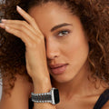 Smart Caviar Black Ceramic and Stainless Steel Infinite Watch Bracelet on wrist, showcasing luxury beaded band design, partially covering a person's face, highlighting elegance and craftsmanship.
