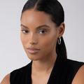 Young woman showcasing Caviar Spark Beaded Diamond Hoop Earrings in sterling silver with Caviar beading, emphasizing a modern silhouette and refined style.