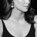 Close-up of a woman wearing Maya Three Onyx Circle Drop Earrings, featuring polished onyx circles with sterling silver caviar beading.