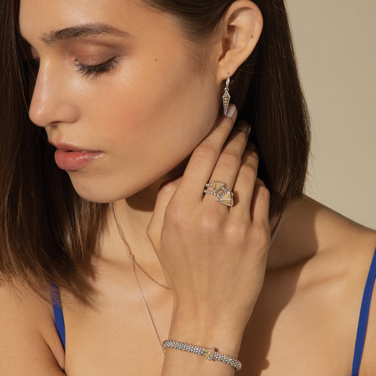 Profile of a woman wearing KSL Drop Pyramid Hoop Earrings with gold and silver beading, paired with a pyramid ring, bracelet, and layered necklaces.