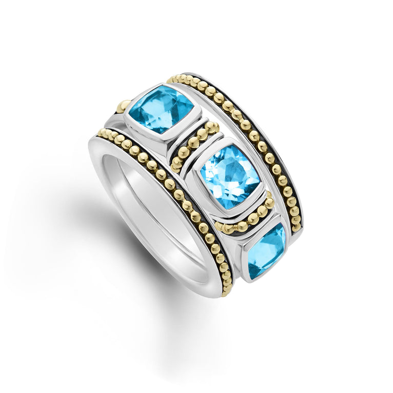 A trio of stacking rings with one swiss blue topaz ring and two 18K gold Caviar beaded rings with sterling silver accents.
