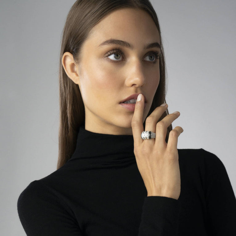Woman models the Black Caviar Black Three Station Ceramic Caviar Diamond Ring, showcasing its sterling silver, diamond rows, and caviar beading.