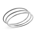 Signature Caviar Silver Bangle Set featuring three sterling silver bangles with distinct textures: classic Caviar beading and striking sugarloaf motif, showcasing elegant craftsmanship.