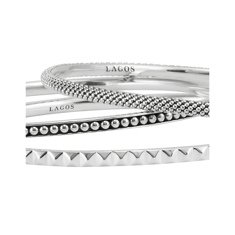 Signature Caviar Silver Bangle Set features three sterling silver bangles, including two with Caviar beading and one with a sugarloaf motif, showcasing LAGOS craftsmanship.