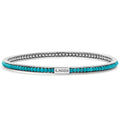 Turquoise gemstones set with smoothly polished sterling silver forms this round bangle detailing the LAGOS logo.