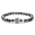 Snowflake obsidian gemstone beaded bracelet with a sterling silver Caviar skull.
