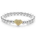 A highly polished sterling silver bracelet with an 18k gold and silver Caviar beaded heart accent.