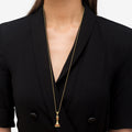Person wearing a black blazer with a LAGOS Rare Wonders Ruby and Diamond Queen Pendant Necklace, featuring an 18k gold queen chess piece adorned with rubies and diamonds.