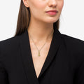 Close-up of a person wearing a LAGOS Rare Wonders 18K Gold King Pendant Necklace, featuring a tiered tower design on an adjustable gold chain.