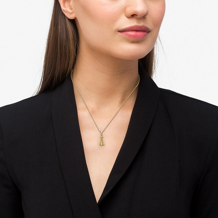 Close-up of a person wearing a LAGOS Rare Wonders 18K Gold King Pendant Necklace, featuring a tiered tower design on an adjustable gold chain.